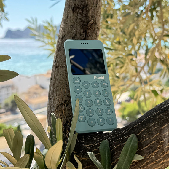 MP02 light blue used for the digital detox challenge, placed on an olive tree with a Mediterranean view.